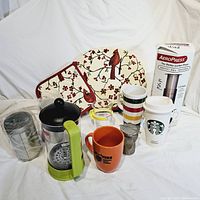 Full lot showing coffee and tea accessories including AeroPress, mugs, tea canisters, and fabric linens