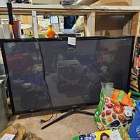 Front view of Samsung 51 inch plasma TV on stand surrounded by household items showing overall condition.