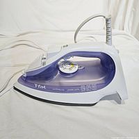 Side profile of purple and white Tefal Ultraglide iron showing dial, buttons and soleplate