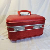 Closed ruby red hardshell Travelite suitcase with red handle and silver trim accents.