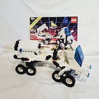 Front and side view of Lego Futuron Interplanetary Rover with trailer and instruction booklet in background
