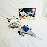 Photo showing the assembled Lego spaceship and instruction booklet laid on a white background.