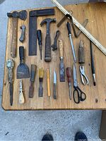 Full lot of antique and retro hand tools arranged on wood surface showing variety of tools