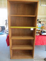 Front view of the wooden bookcase showing four shelves and an approximately 32 inch wide interior shelf span.