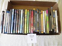 Photo of the boxed collection of 22 assorted DVDs standing vertically showing a mix of animated, children's, and live-action movie titles in good used condition.