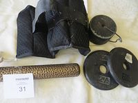 Photo showing all miscellaneous weights including fabric ankle/wrist weights, metal plates, and a textured metal bar.