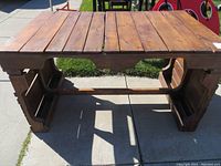 Solid rectangular wooden table constructed from pallet wood, showing top and side views in daylight outdoors.