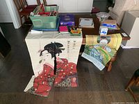 Overview of all items on table including Asian themed fabrics, notebooks, pens, crayons, peg games, gift wrap and bags.