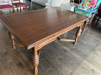 Top view of the wood dining table showing integrated leaves and surface condition