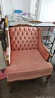 Front view of the full armchair showing tufted backrest, seat cushion, and carved wooden frame.