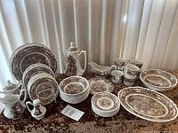 Full view of Americana Style House Ironstone dinnerware set with various plates, bowls, teapot, creamer, sugar bowl, gravy boat, and cups on display