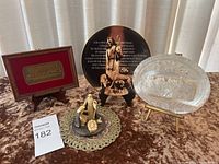 Photo showing the complete religious bundle on table including framed Last Supper plaque, crucifix plaque, glass plaque and two figurines on a small doily.