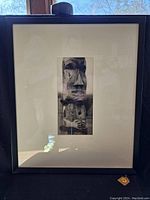 Full view of framed print showing black frame, glass, and off-white mat board