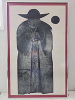 Full frontal view of the framed etching featuring a man in a cloak with a large hat, including red mat and silver frame.