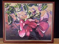 Framed oil painting showing pink Mandevilla flowers with green leaves, signed by Joane Moran, overall view of the artwork and frame.