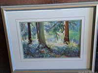 Framed pastel drawing of a wooded scene with sunlight and shade contrasting through the trees.
