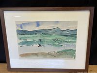 Frontal image of the framed watercolour painting featuring blue and green abstract landscape with signature visible.