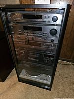 Full view of black stereo cabinet with stacked components