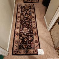 Full view of one wool and silk blend runner showing floral and beige border on dark brown center.