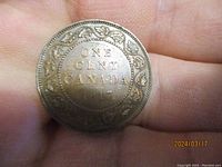 Reverse side of the 1917 Canadian one cent coin showing denomination, country, year and maple leaf border.