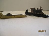 Both railroad spike sculptures side by side showing size and detail.