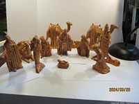 Full view of all nativity scene's ceramic figurines arranged on white surface, showing tallest pieces about 9 inches tall.