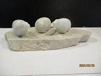 Front angled view showing three white marble bird figures on rough marble base.