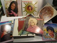 Photo of several LP albums including Loretta Lynn's Greatest Hits, a large stack of 30 vinyl records, and multiple Patsy Cline albums, showing album covers and general condition.