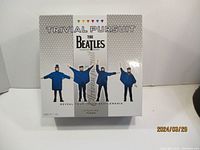 The Beatles Trivial Pursuit board game box front showing band member figures and multicolor game icons