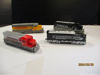Front angle view of all four toy trains showing colors and labels: North Southern, Power Pacific, Express, New York Central.