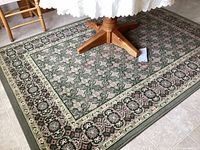 Area rug under a round wooden table showing detailed pattern and condition.