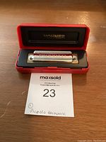 Hohner Piccolo Harmonica inside open red plastic case with black foam insert, showing the metal harmonica with 'HOHNER' and 'PICCOLO NO 424/2' engraved on it.