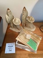 Two marble bookends and a rectangular glass box with lid placed on wooden surface