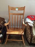 Front view of the solid pine rocking chair showing the slatted backrest, armrests, and overall condition.