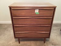 Front view showing four drawers with curved fronts and recessed handles