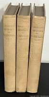 Spines of all three volumes showing titles and embossed decorative spine design.