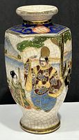 Photo showing side of hexagonal vintage Japanese porcelain vase with hand painted traditional Japanese figure in colorful clothing, crackle glaze finish and gold accents.