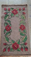 Full view of antique hooked rug with central blank area and floral border