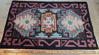 Full view of hooked rug showing entire border and center motifs