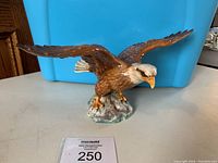 Front view of Beswick 1018 Bald Eagle ceramic figurine with wings spread, displayed against a blue background.