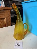 Full view of the amber glass decanter showing its elongated neck and stopper.