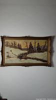 Full view of the framed oil painting showing winter landscape with stream and mixed trees.