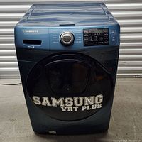 Front view of blue Samsung washing machine with closed door and control panel visible