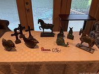 Full view showing all decorative items on table including birds, horses, crosses, snail, and brass mice on cheese slices