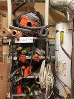 Overview of full metal storage rack on wheels filled with various power tools, measuring tapes, hand tools, and accessories.
