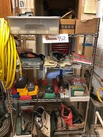 Shelving unit with various tools, pouches, and small toolboxes on multiple shelves