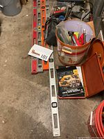 Wide view showing four levels, bucket with assorted tools, and wooden box with parts.
