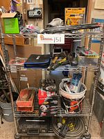 Photo of metal shelving unit filled with tools and boxes inside a garage