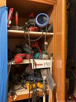 Shelf with power tools including electric drills, circular saw, angle grinder, and other equipment