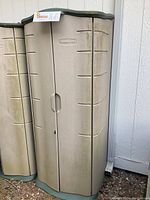 Rubbermaid outdoor storage shed front view showing double doors and beige textured plastic with green base and top edges.